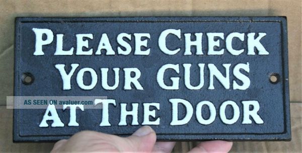 Targa Decorativa In Metallo 'Check Your Guns At The Door' 28x12 Cm - Vintage Stile Americano